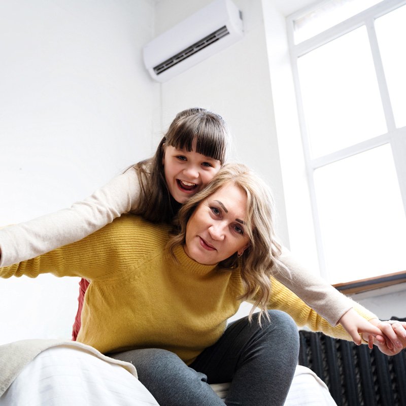 Mother and daughter are enjoying the living room wall-mounted AC installed in Seattle